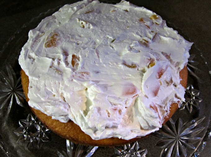 Peachy Keen Cake with Cool Whip Frosting requires a boxed cake mix, canned peaches, peach yogurt and Cool Whip. It makes a boxed cake mix taste homemade.