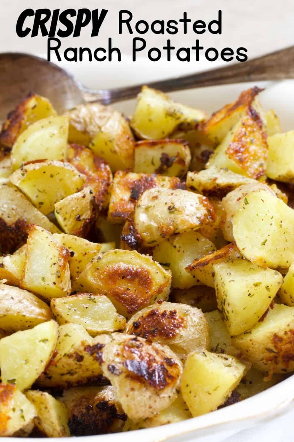 Close up view of half a bowl of potatoes with the words crispy roasted ranch potatoes.