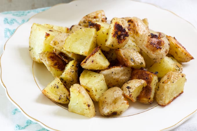 Close up side view of one serving of potatoes in a china plate.