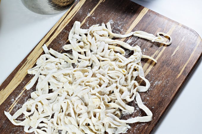 Angled shot of homemade egg noodles on a cutting board. 