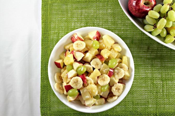 This is a refreshing fruit salad that combines canned pineapple, fresh apples, grapes, coconut, and honey with a dash of cinnamon.