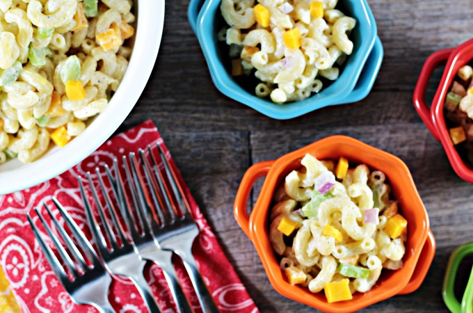 Macaroni & Cheese Salad combines elbow macaroni, cheese cubes, celery, red onion, Dijon mustard, mayo, sour cream, salt, pepper, and sugar. 