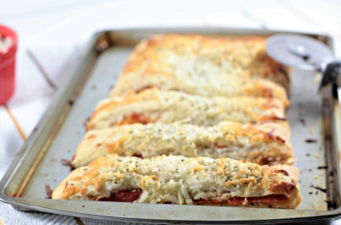 Pepperoni Stuffed Pizza Bread features premade crust, sauce, pepperoni, mozzarella & Parmesan cheese, Italian seasoning, and garlic powder. Easy and quick.