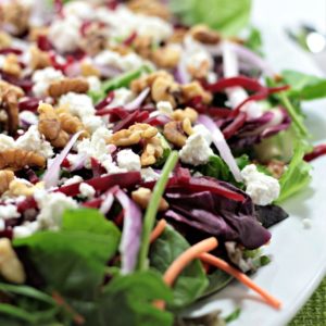 Baby Greens Salad with Beets & Goat Cheese also features red onion and walnuts, topped with orange vinaigrette. Great for winter or any time of the year.