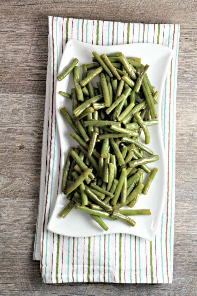 Overhead shot of an entire plate of green beans on white plate.