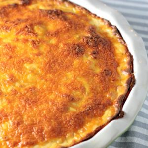 Cheesy Scalloped Potatoes feature thinly slice layered potatoes topped with a cheesy béchamel sauce made of milk, butter, flour, onion, and cheese.