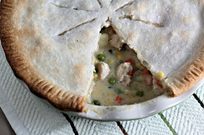 Classic Chicken Pot Pie features store bought crust, cooked chicken, peas, corn, carrots, green beans, and potatoes in a creamy sauce. 