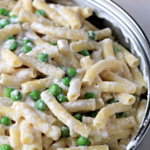 Pasta with Peas and Ricotta features olive oil, butter, ziti, chicken broth, Ricotta, Parmesan, frozen peas, lemon, shallots and garlic.