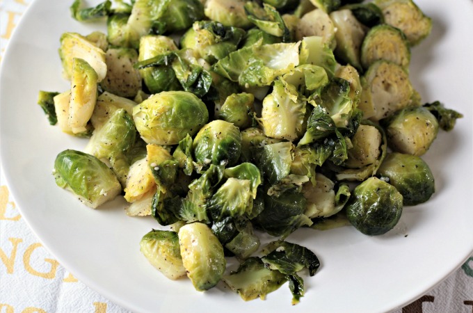 Super Easy Pan Fried Fresh Brussels Sprouts combine Brussels sprouts, olive oil, garlic, salt, pepper, and water to make a healthy and easy side dish.