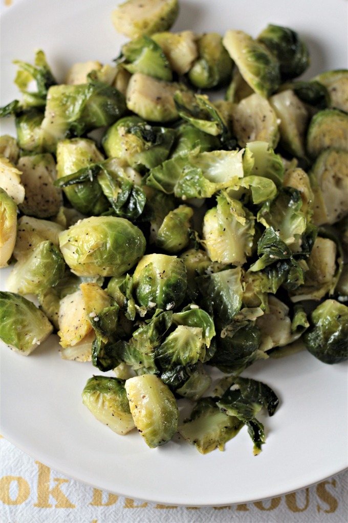 Super Easy Pan Fried Fresh Brussels Sprouts combine Brussels sprouts, olive oil, garlic, salt, pepper, and water to make a healthy and easy side dish.