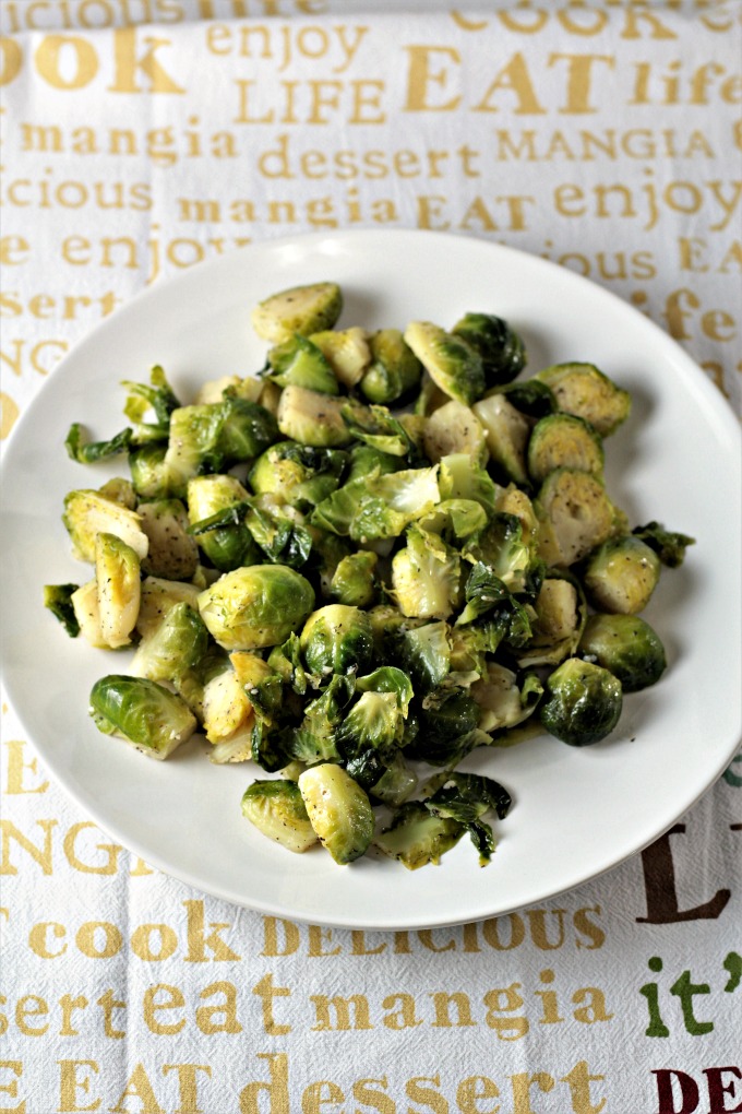 Super Easy Pan Fried Fresh Brussels Sprouts combine Brussels sprouts, olive oil, garlic, salt, pepper, and water to make a healthy and easy side dish.