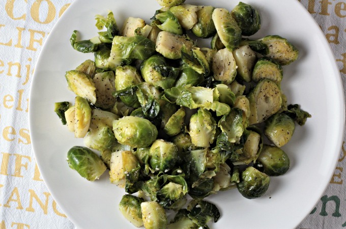 Super Easy Pan Fried Fresh Brussels Sprouts combine Brussels sprouts, olive oil, garlic, salt, pepper, and water to make a healthy and easy side dish.