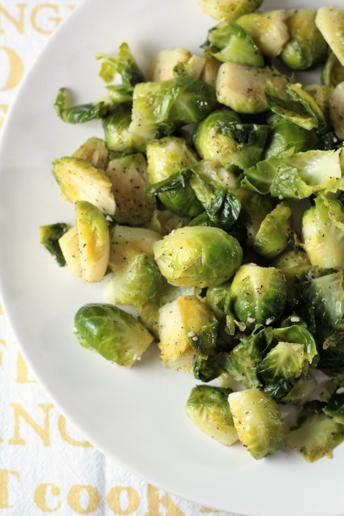 Super Easy Pan Fried Fresh Brussels Sprouts combine Brussels sprouts, olive oil, garlic, salt, pepper, and water to make a healthy and easy side dish.