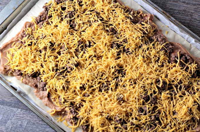 Super Easy Taco Pizza: Premade pizza dough, refried beans, seasoned ground beef, cheese, lettuce, tomatoes, and salsa. Quick, easy and kid friendly.