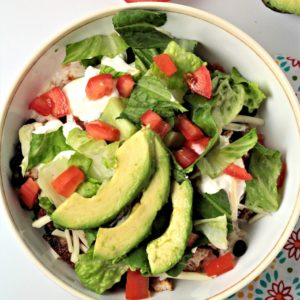 Grilled Chicken Burrito Bowls have rice, beans, chicken, salsa, cheese, lettuce, tomato, sour cream and avocado. A great Mexican meal made at home!