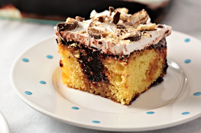 Twix Poke Cake combines boxed yellow cake mix, caramel topping, chocolate pudding, whipped topping and Twix candy bars to make an easy and yummy dessert!