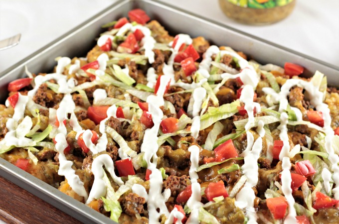 Loaded Beef Tater Tots (Totchos) feature nacho ingredients (ground beef, cheese, sour cream, salsa, and tomatoes) on tater tots instead of tortilla chips. 