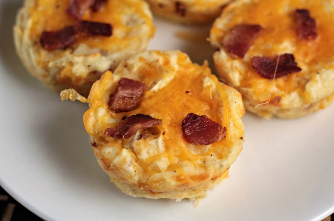 Baked Cheesy Mashed Potato Cups combine mashed potatoes, cheese, bacon, an egg, salt and pepper to make a versatile kid-friendly side dish or appetizer. 