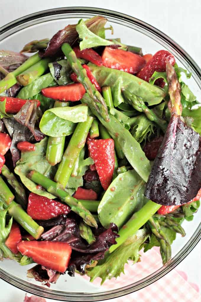Asparagus Strawberry Mixed Green Salad features fresh asparagus, strawberries and mixed greens (red, green and romaine lettuce, spinach, arugula, and raddichio) and is topped with a simple viniagrette made from olive oil, balsamic vinegar and a little bit of salt. Fresh and delicious!