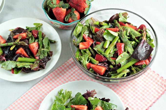 Asparagus Strawberry Mixed Green Salad features fresh asparagus, strawberries and mixed greens (red, green and romaine lettuce, spinach, arugula, and raddichio) and is topped with a simple viniagrette made from olive oil, balsamic vinegar and a little bit of salt. Fresh and delicious!