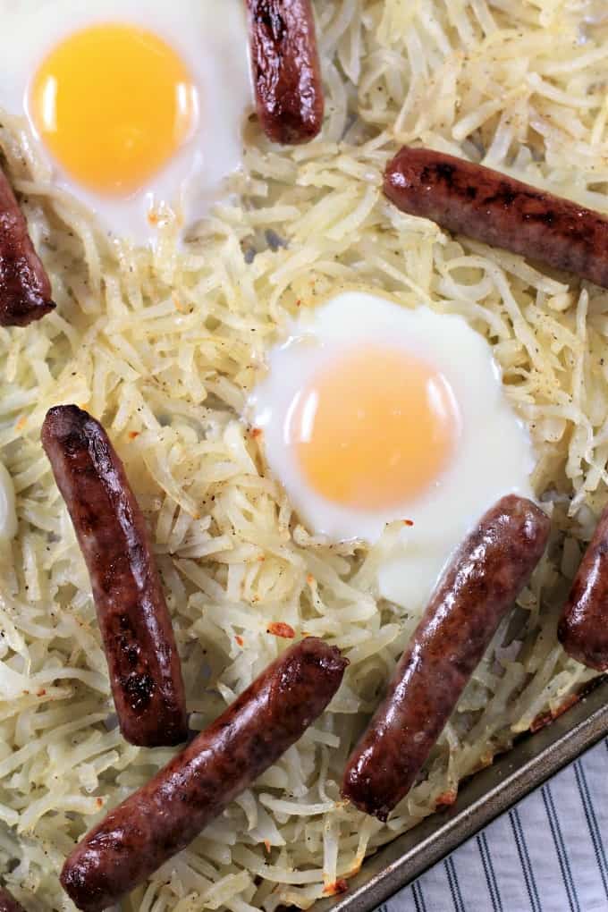 Sausage Sheet Pan Breakfast features store bought hash browns, link sausage, and eggs seasoned with salt and pepper and a splash of melted butter. It is an easy and delicious breakfast, brunch or dinner cooked on one sheet pan. And, clean up is a breeze!