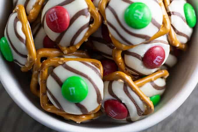M & M's Hershey Hugs Pretzel Bites feature Hershey Hugs slightly melted on a salty pretzel topped with an m & m. Perfectly and sweet and salty!