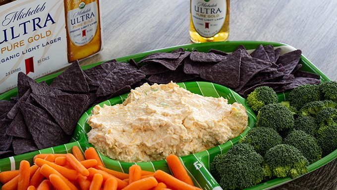 Cheesy Ranch Beer Dip combines cream and cheddar cheese, bottled ranch dressing, beer, green onions and cayenne pepper to make a creamy and spicy dip.