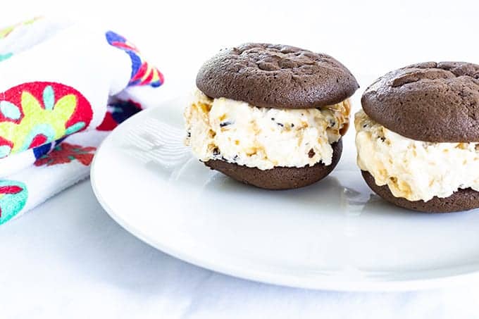 Mini Ice Cream Sandwiches are soft chocolate cookies filled with ice cream that has chocolate chunks and swirls of sea salt caramel to make a yummy dessert!