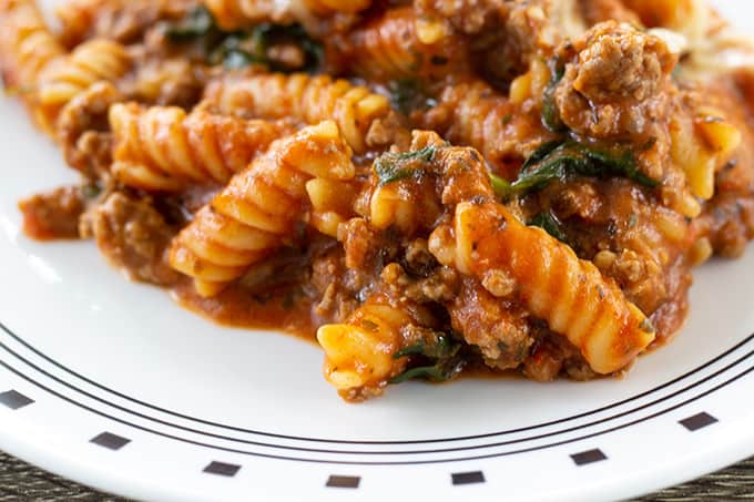 Very close up shot of rotini with beef on a white plate. 