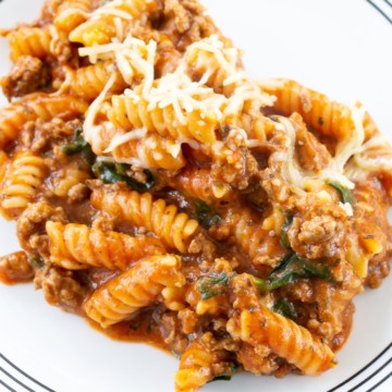 close up view of one pot meaty marinara pasta on a white plate.