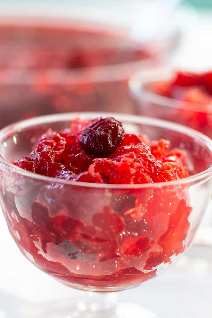 Side view of a small glass bowl full of cranberry raspberry jello salad