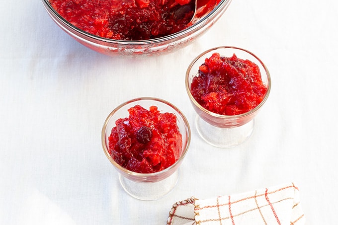 Overhead view of one large and two small glass bowls of cranberry raspberry jello salad.