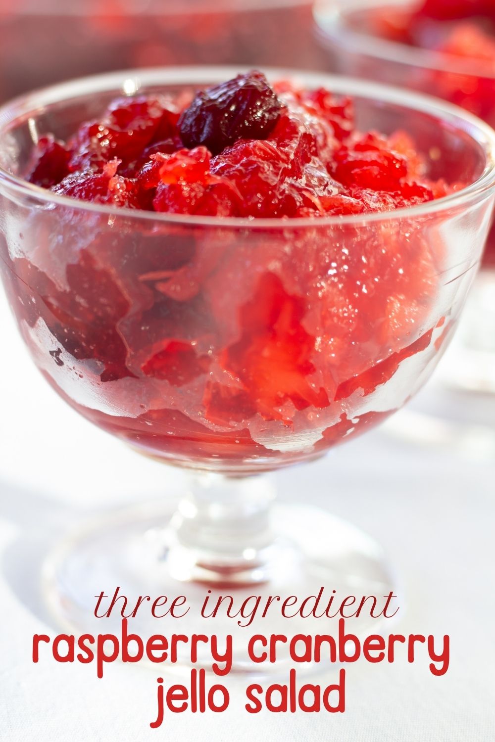 A bowl of cranberry raspberry jello salad with the title in red below it.