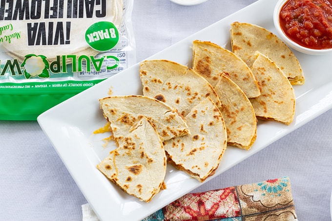 Skinny Bean & Cheese Quesadillas feature refried beans and cheese. They are made with a low fat CAULIPOWER cauliflower tortilla, making them good for you! 