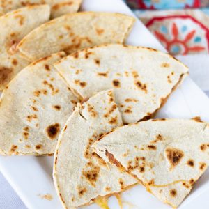 Skinny Bean & Cheese Quesadillas feature refried beans and cheese. They are made with a low fat CAULIPOWER cauliflower tortilla, making them good for you!