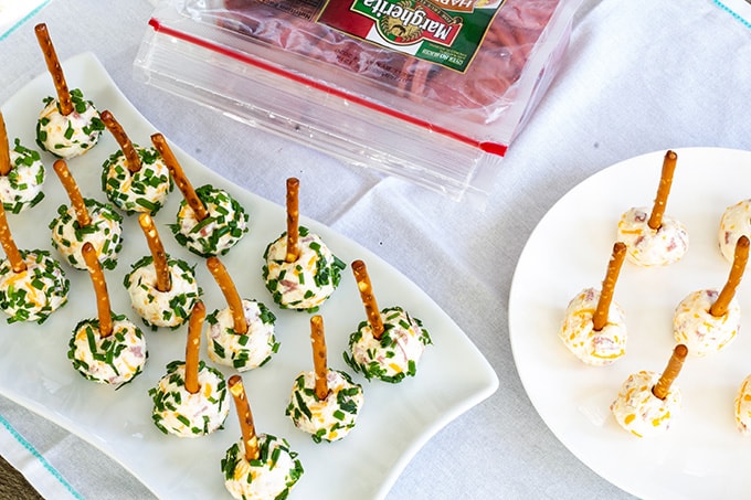 Mini Salami Cheese Balls feature hard salami, cream cheese, cheddar cheese, mayo, Dijon mustard and are covered with chives. Served with a pretzel stick. 