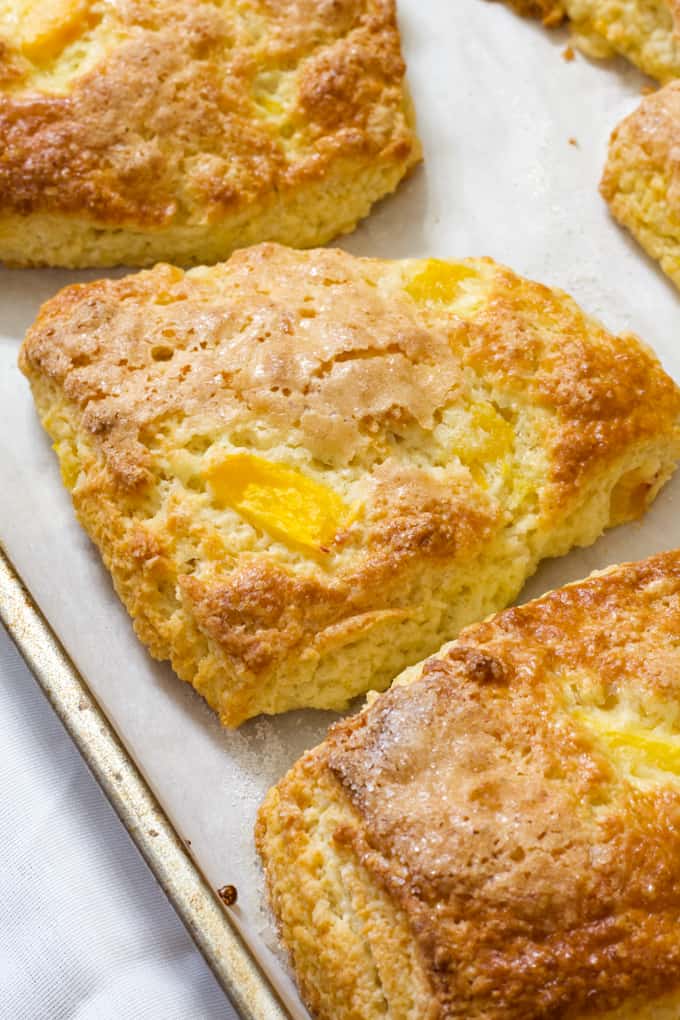 Peach Yogurt Scones are an easy to make delicious biscuit like treat made with butter, flour, sugar, Greek yogurt and frozen peaches.