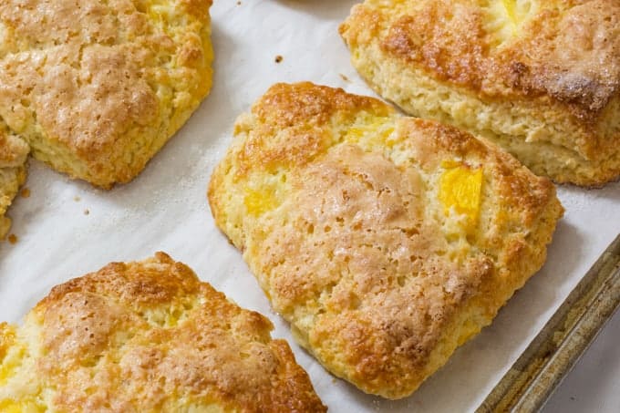 Peach Yogurt Scones are an easy to make delicious biscuit like treat made with butter, flour, sugar, Greek yogurt and frozen peaches.