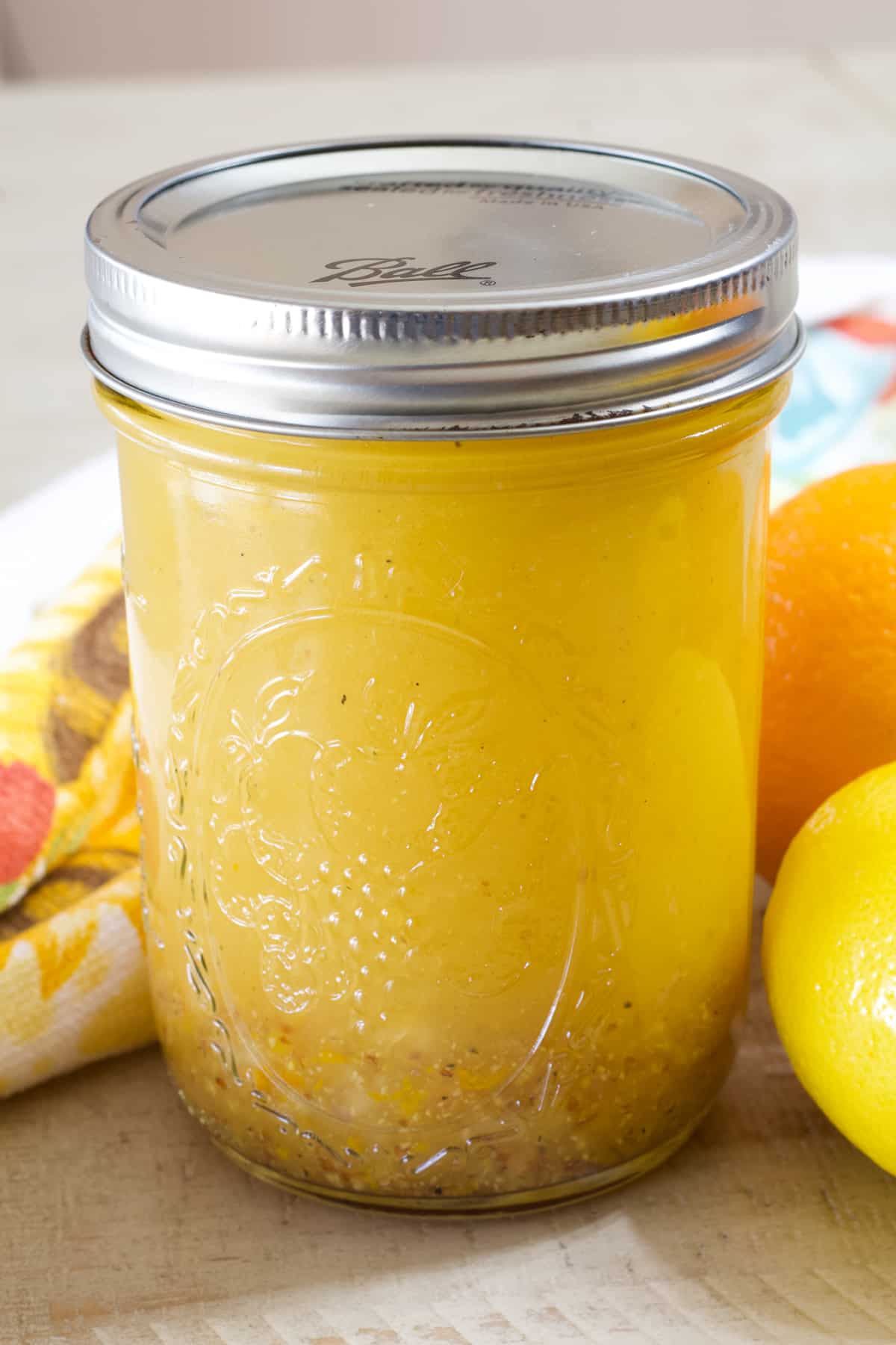 Side view of a mason jar filled with citrus vinaigrette. 