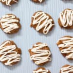 Overhead view of carrot cake cookies on a light blue cookie sheet.