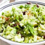 A close up overhead view of a bowl of brussels sprout salad