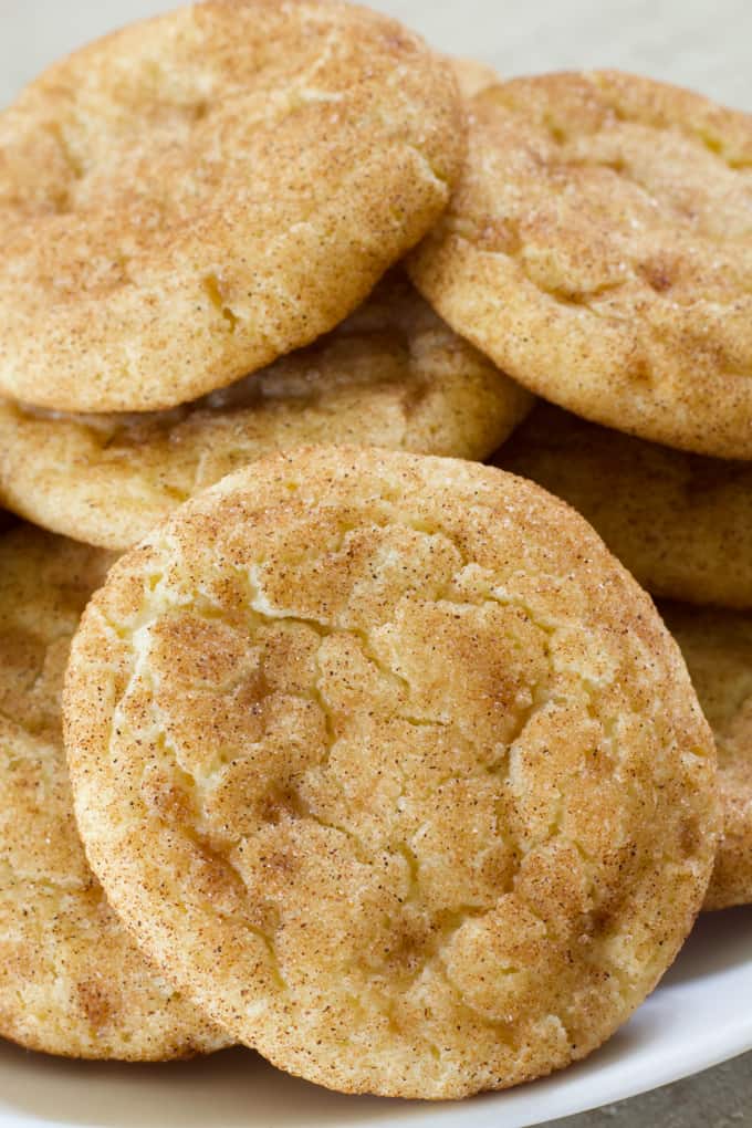 Very close up shot of one snickerdoodle leaning up against a bunch of cookies.