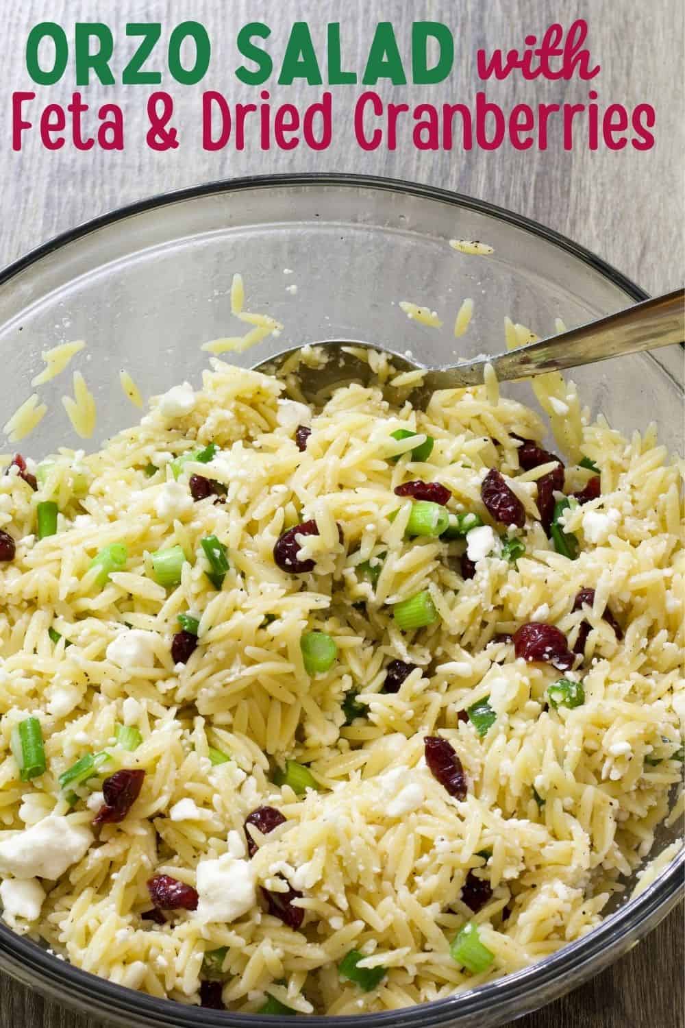 A large bowl of orzo salad with feta and dried cranberries.