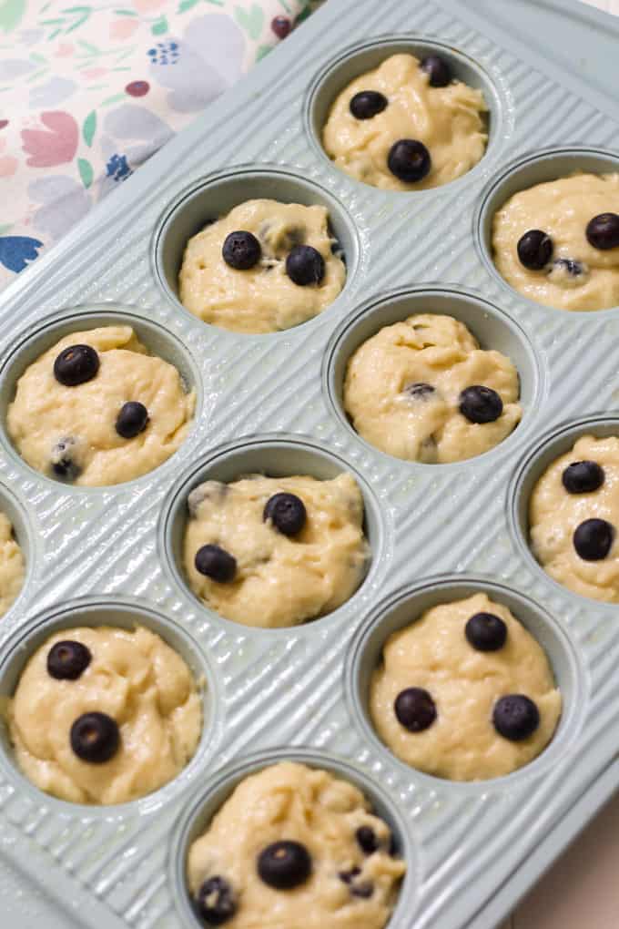 The unbaked muffin batter in a twelve cup muffin tin.
