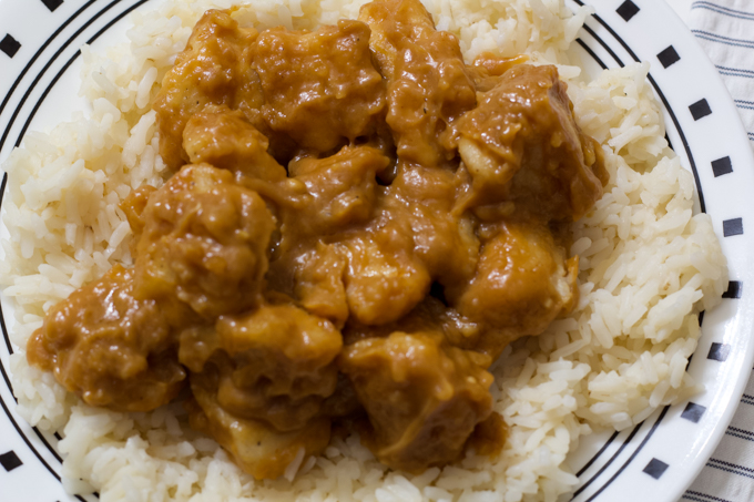 A close up overhead view of peanut butter chicken on a white rice.
