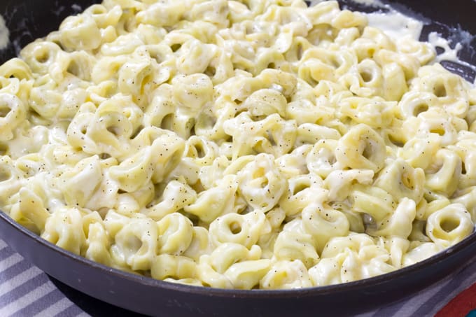 Close up view of a skillet filled with tortellini alla panna