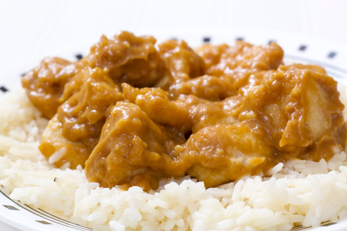 A close up side view of the peanut butter chicken on a bed of white rice.