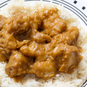 A close up side view of the peanut butter chicken on a bed of white rice.