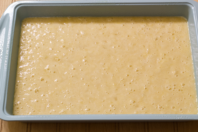 The unbaked cake batter in a turquoise 9 X 13 baking pan.