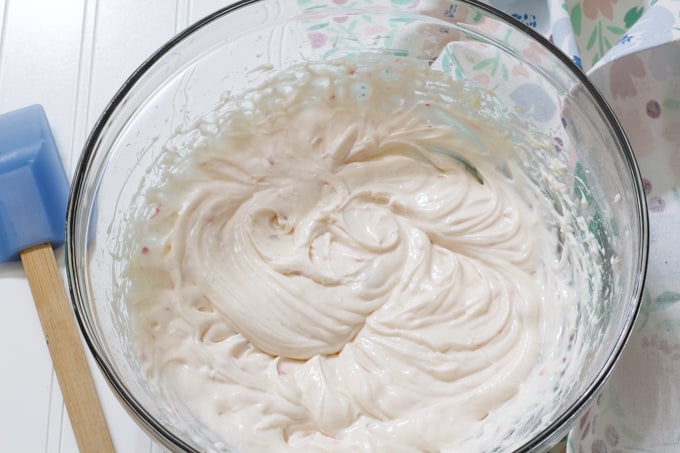 Cream cheese, sugar and yogurt mixed together in a large glass bowl.
